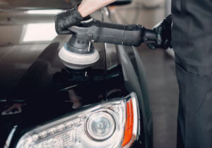 Homem passando uma politriz no carro